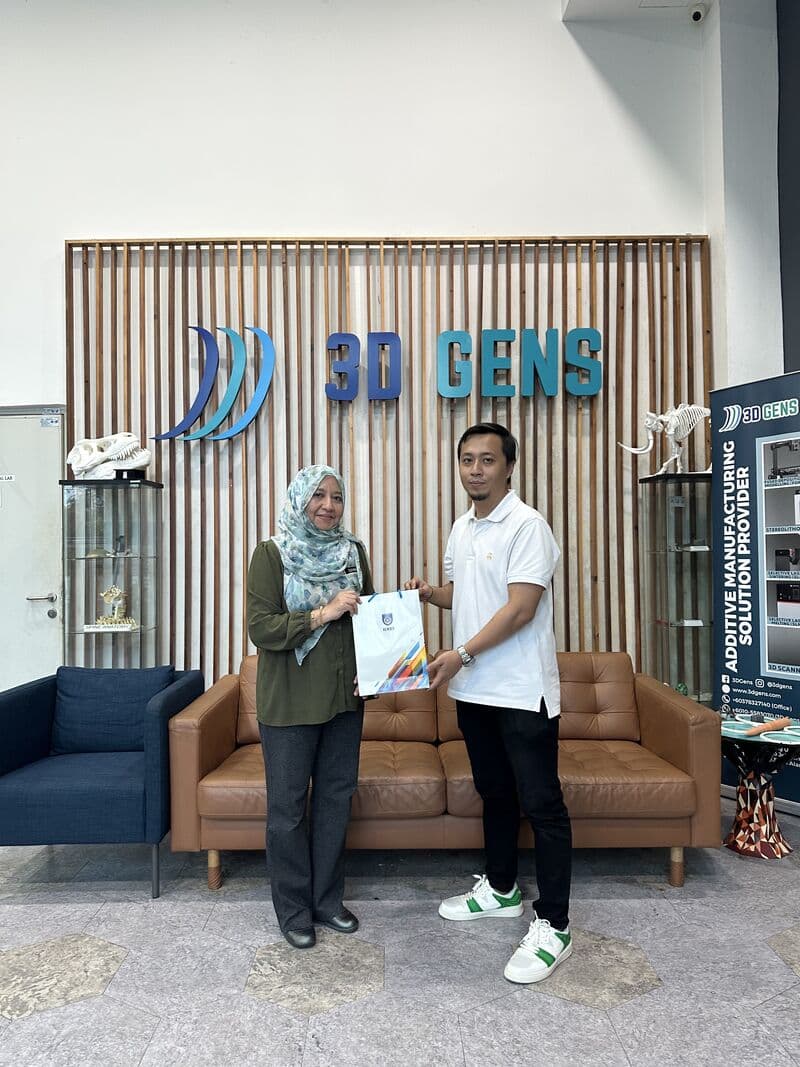 IKTBN representative presents a souvenir bag to a 3D Gens representative at the 3D Gens office lobby