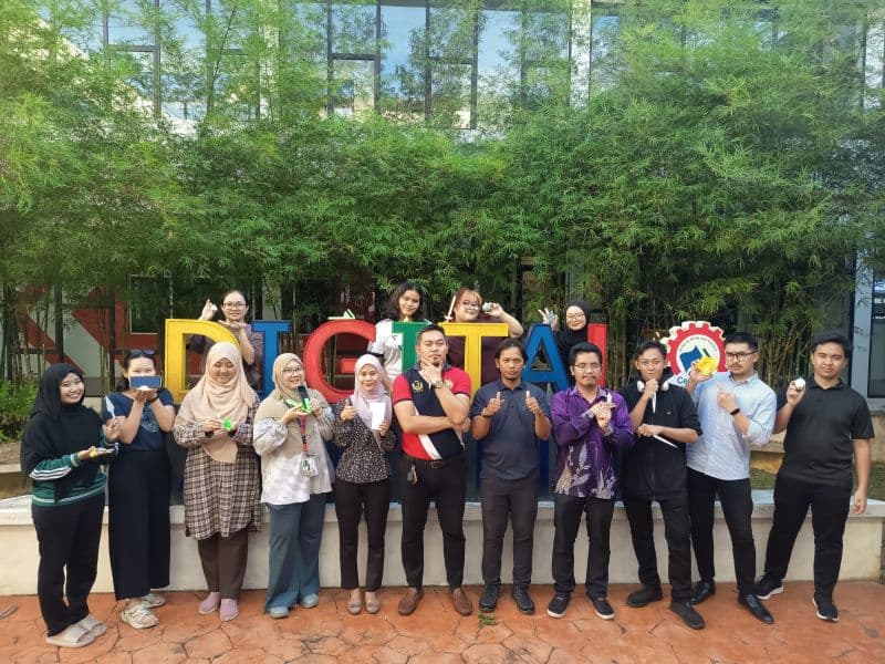 Training participants display their 3D printed objects in front of the DIGITAL installation at the Bintawa training venue