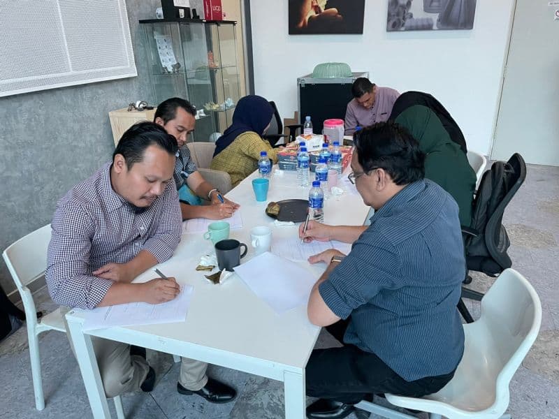 Participants completing written exercises during the SLM 3D metal printing workshop
